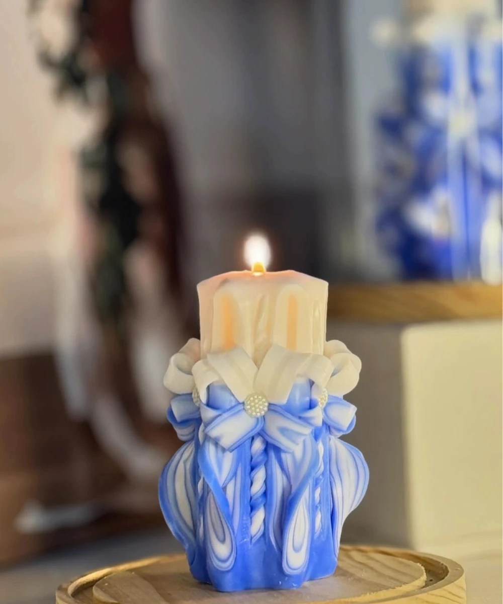 Handmade carved candle in sky blue and white with smooth artistic curves, placed in an elegant gift box.