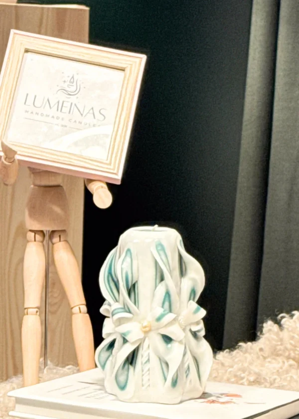 Close-up of a hand-carved candle in olive green and white layers, showcasing detailed curls and folds, made from high-quality paraffin wax and presented in a luxurious gift box.