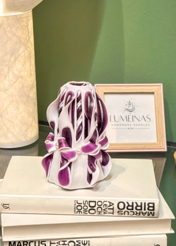 Hand-carved white and purple candle with intricate layers and elegant design, crafted as a decorative piece.